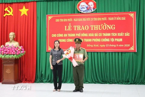 Đại diện Thành ủy Đồng Xoài, tỉnh Bình Phước trao thưởng cho công an thành phố Đồng Xoài. (Ảnh: Đậu Tất Thành/TTXVN)