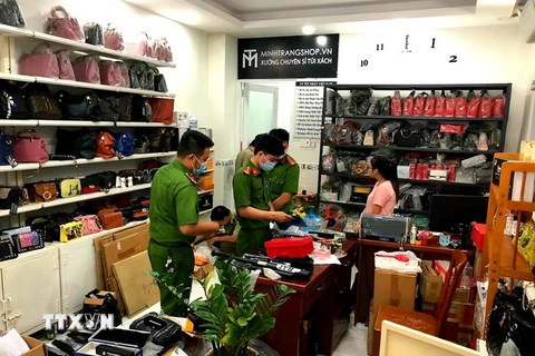 Lực lượng chức năng kiểm tra cửa hàng kinh doanh túi xách bắt giữ lô công cụ hỗ trợ cực lớn. (Ảnh: TTXVN phát)