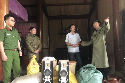 Chính quyền địa phương giúp người dân xã Hương Liên thu dọn đồ đạc để chuyển đến nơi an toàn. (Ảnh: Phan Quân/TTXVN)