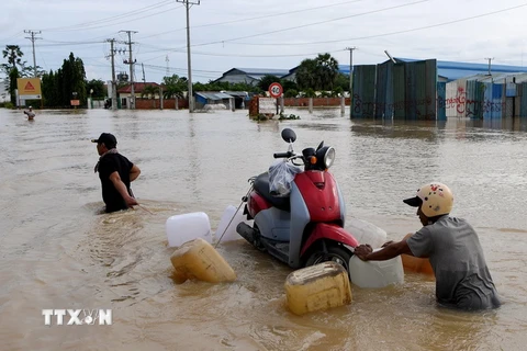 Người dân sơ tán khỏi các khu vực ngập lụt ở Phnom Penh, Campuchia, ngày 17/10. (Ảnh: AFP/TTXVN)