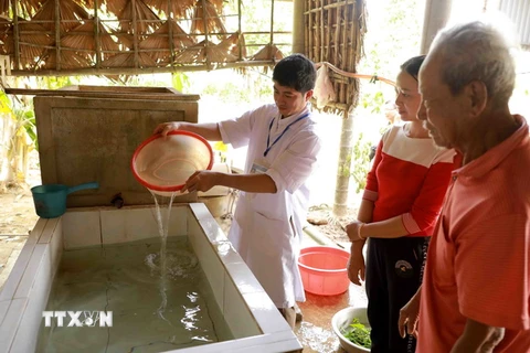 Nhân viên Trung tâm Y tế dự phòng huyện Lệ Thủy, tỉnh Quảng Bình tiến hành khử khuẩn nước sinh hoạt bằng dung dịch Cloramin B cho hộ dân. (Ảnh: Vũ Sinh/TTXVN)