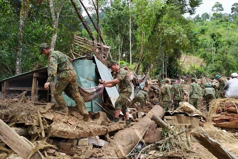 Lực lượng chức năng tìm kiếm các nạn nhân còn lại tại hiện trường sạt lở Trà Leng. (Ảnh: Trần Lê Lâm/TTXVN)
