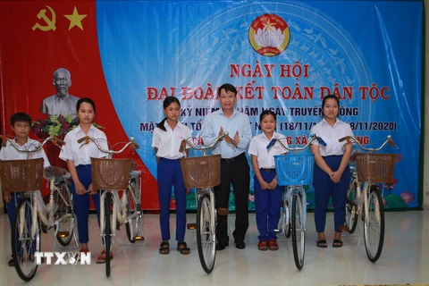 Ông Nguyễn Đức Lợi, Ủy viên Trung ương Đảng, Tổng Giám đốc TTXVN, trao xe đạp cho các em học sinh ở xã Triệu Trung. (Ảnh: Hồ Cầu/TTXVN)