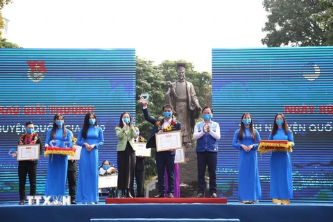 Bí thư thứ nhất Trung ương Đoàn, Chủ tịch Trung ương Hội Liên hiwwpj Thanh niên Việt Nam Nguyễn Anh Tuấn (bên phải) trao Giải thưởng Tình nguyện Quốc gia 2020 cho các tập thể, cá nhân. (Ảnh: TTXVN)