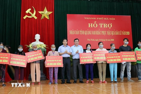 Người dân huyện Phú Ninh, tỉnh Quảng Nam bị thiệt hại do bão lũ nhận quà hỗ trợ từ Hà Nội. (Ảnh: Trần Tĩnh/TTXVN)