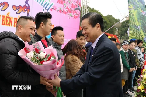 Chủ tịch UBND tỉnh Hà Giang Nguyễn Văn Sơn tặng hoa cho những du khách đầu tiên “xông đất” du lịch Hà Giang năm 2021. (Ảnh: TTXVN phát)