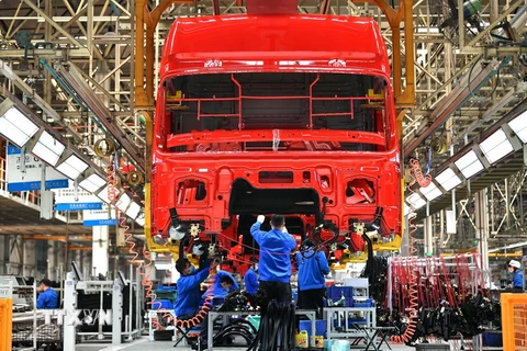 Công nhân làm việc tại dây chuyền sản xuất xe tải hạng nặng của Tập đoàn sản xuất ô tô Thiểm Tây, Trung Quốc ngày 23/4/2020. (Ảnh: THX/TTXVN)