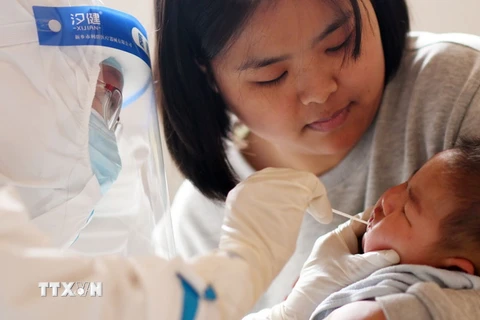 Nhân viên y tế lấy mẫu xét nghiệm COVID-19 cho một em bé ở tỉnh Hà Bắc, Trung Quốc, ngày 13/1. (Ảnh: THX/TTXVN)