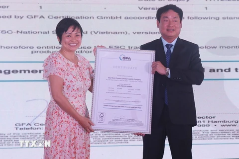 Bà Nguyễn Thị Tú Anh (trái), Trưởng Văn phòng đại diện GFA, CHLB Đức tại Việt Nam trao chứng chỉ FSC cho ông Trần Nguyên Tú, Chủ tịch Công ty TNHH Lâm nghiệp Quy Nhơn. (Ảnh: Phạm Kha/TTXVN)