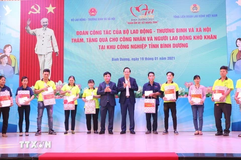 Bộ Trưởng Đào Ngọc Dung tặng quà Tết cho các công nhân có hoàn cảnh khó khăn. (Ảnh: Huyền Trang/TTXVN)