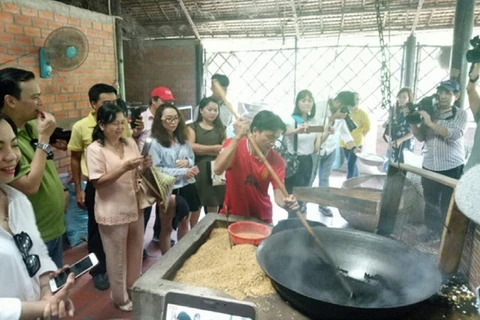 Du khách tham quan quy trình sản xuất Cốm. (Nguồn: vinhlongtourist.vn)