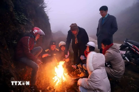 Du khách và người dân đốt lửa sưởi ấm ở núi. (Ảnh: TTXVN phát)