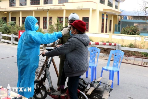 Lực lượng chức năng đo thân nhiệt tại chốt kiểm dịch thôn Nhiêu Đậu, xã Lâm Thao, huyện Lương Tài. (Ảnh: Đinh Văn Nhiều/TXVN)