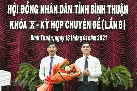 Ông Dương Văn An, Bí thư Tỉnh ủy Bình Thuận tặng hoa chúc mừng ông Lê Tuấn Phong, Chủ tịch UBND tỉnh Bình Thuận. (Ảnh: Nguyễn Thanh/TTXVN)