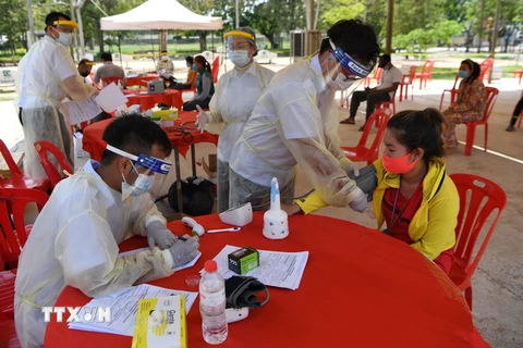 Nhân viên y tế xét nghiệm COVID-19 cho dân tại Phnom Penh, Campuchia. (Ảnh: AFP/TTXVN)
