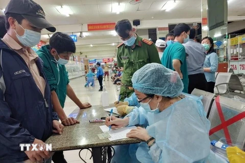Nhân viên Trung tâm Y tế quận Bình Thạnh, TP.HCM chuẩn bị lấy mẫu xét nghiệm tại Bến xe Miền Đông. (Ảnh: TTXVN phát)