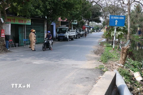 Giám sát đường vào xã Hoa Động, huyện Thủy Nguyên, nơi bệnh nhân sinh sống. (Ảnh: Hoàng Ngọc/TTXVN)