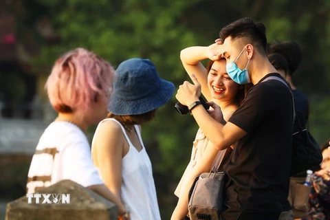 Những thanh niên Hà Nội thư giãn, tận hưởng không khí trong lành bên Hồ Tây. (Ảnh: Lâm Khánh/TTXVN)