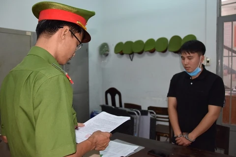 Bị can Lý Chính Thắng đang nghe công an đọc quyết định khởi tố, lệnh bắt tạm giam. (Nguồn: cand)