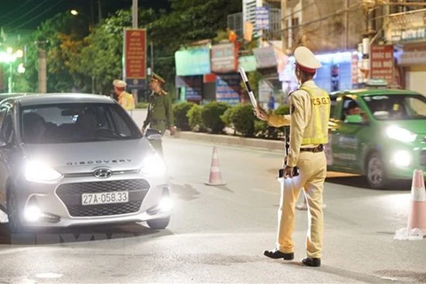 Cảnh sát giao thông dừng phương tiện để kiểm tra nồng độ cồn đối với các lái xe. (Ảnh: Xuân Tư/TTXVN)
