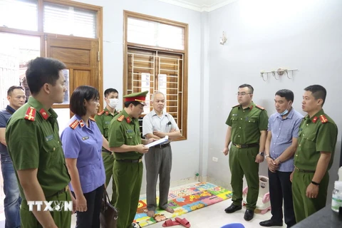 Cơ quan Cảnh sát điều tra, Công an tỉnh Sơn La đọc lệnh bắt bị can Hoàng Vũ Quyển. (Ảnh: TTXVN phát)