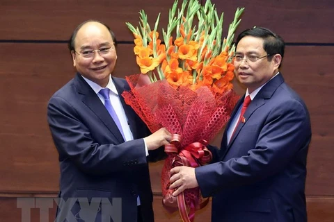 Thủ tướng Phạm Minh Chính tặng hoa Chủ tịch nước Nguyễn Xuân Phúc, Thủ tướng Chính phủ nhiệm kỳ 2016-2021. (Ảnh: Thống Nhất/TTXVN)