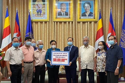 Chủ tịch Liên hiệp các tổ chức hữu nghị Việt Nam Nguyễn Phương Nga trao cho Đại sứ Campuchia tại Việt Nam Chay Navuth khoản hỗ trợ 500 triệu đồng. (Nguồn: qdnd)