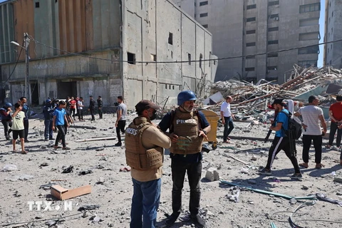 Phóng viên Hãng AP tại hiện trường đổ nát của Tòa tháp Jala, nơi đặt văn phòng một số hãng truyền thông quốc tế, sau khi máy bay Israel oanh tạc Dải Gaza, ngày 15/5. (Ảnh: AFP/TTXVN)