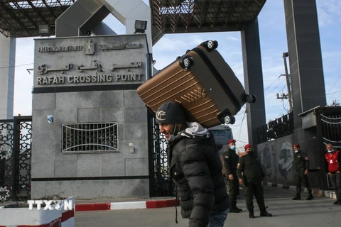 Người dân Palestine đi qua cửa khẩu Rafah ở khu vực biên giới phía Nam Dải Gaza, giáp Ai Cập. (Ảnh: AFP/TTXVN)