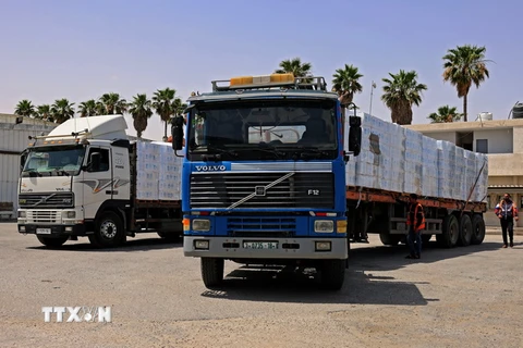 Xe chở hàng cứu trợ qua cửa khẩu Rafah vào Dải Gaza, ngày 21/5. (Ảnh: AFP/TTXVN)