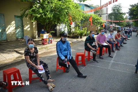 Cử tri thực hiện giãn cách tại khu vực bỏ phiếu số 28, phường Tây Thạnh, quận Tân Phú, TP.HCM. (Ảnh: Mạnh Linh/TTXVN)