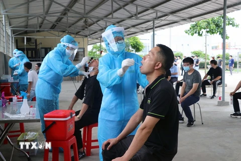 Lực lượng y tế lấy mẫu xét nghiệm virus SARS-CoV-2. (Ảnh: Hoàng Ngọc/TTXVN)
