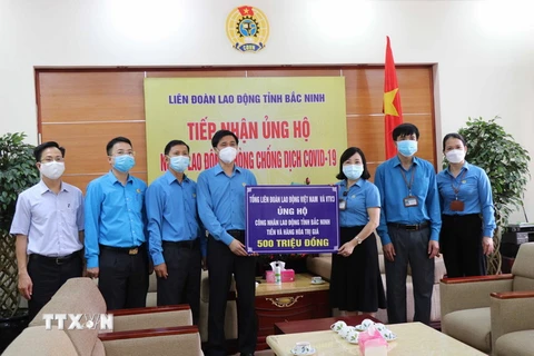 Liên đoàn Lao động tỉnh Bắc Ninh tiếp nhận ủng hộ cho công nhân, người lao động từ Tổng Liên đoàn Lao động Việt Nam và VTV3, Đài Truyền hình Việt Nam. (Ảnh: Thanh Thương/TTXVN)