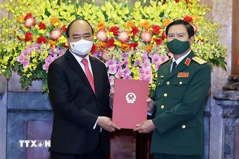 Chủ tịch nước Nguyễn Xuân Phúc tặng chân dung Chủ tịch Hồ Chí Minh cho Thượng tướng Nguyễn Tân Cương. (Ảnh: Thống Nhất/TTXVN)