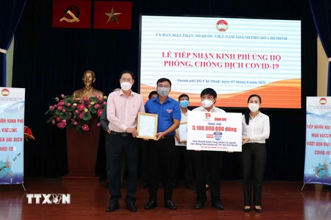 Lãnh đạo Ủy ban Mặt trận Tổ quốc Việt Nam Thành phố tiếp nhận bảng đăng ký ủng hộ tài chính mua Vaccine phòng COVID-19 từ đại diện các tổ chức, doanh nghiệp Thành phố Hồ Chí Minh. (Ảnh: Xuân Khu/TTXVN)