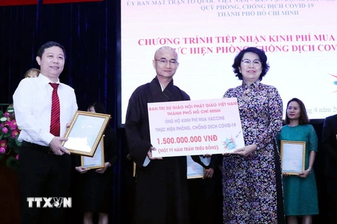 Thượng tọa Thích Thiện Quý, Chánh Thư ký Ban Trị sự Giáo hội Phật giáo Việt Nam Thành phố Hồ Chí Minh (giữa) trao tượng trưng số tiền các Tăng Ni, Phật tử Thành phố ủng hộ để mua vaccine phòng COVID-19. (Ảnh: Xuân Khu/TTXVN)