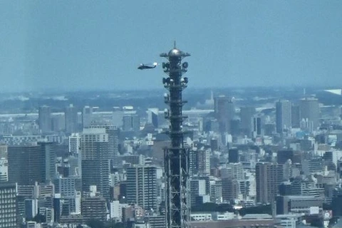 Máy bay trực thăng bay phía sau tháp ăngten cao 220m của Bộ Quốc phòng ở trung tâm Tokyo ngày 11/8/2020. (Nguồn: Mainichi)