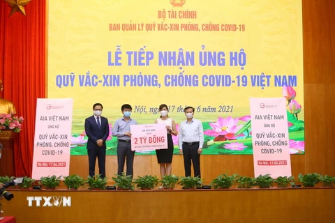 Công ty TNHH Bảo hiểm nhân thọ AIA Việt Nam trao tượng trưng số tiền ủng hộ Quỹ vaccine phòng, chống COVID-19 Việt Nam. (Ảnh: Hoàng Hiếu/TTXVN)