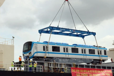 Công tác tháo dỡ toa và đưa toa xe đầu tiên tại cảng Khánh Hội. (Ảnh: Tiến Lực/TTXVN)