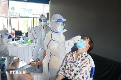Trung tâm y tế thành phố Đồng Xoài tiến hành lấy mẫu test nhanh SARS-CoV-2 các trường hợp tham gia sự kiện. (Ảnh: Đậu Tất Thành/TTXVN)