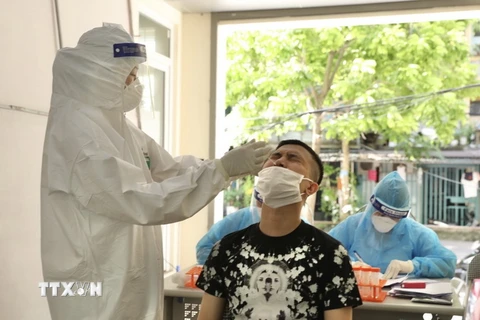 Nhân viên y tế lấy mẫu xét nghiệm cho người có nguy cơ cao trên địa bàn Hà Nội. (Ảnh: Minh Quyết/TTXVN)