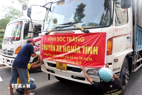 Các xe chở hàng hóa thiết yếu tập hợp chuẩn bị xuất phát về Thành phố Hồ Chí Minh. (Ảnh: Trung Hiếu/TTXVN)