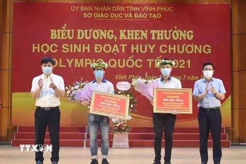 Phó Chủ tịch UBND tỉnh Vĩnh Phúc Vũ Việt Văn trao thưởng cho 2 học sinh đoạt huy chương Olympic quốc tế năm 2021. (Ảnh: Nguyễn Thảo/TTXVN)