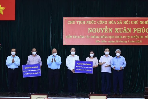 Chủ tịch nước Nguyễn Xuân Phúc chứng kiến các doanh nghiệp trao hỗ trợ công tác phòng, chống dịch COVID-19 cho huyện Hóc Môn và huyện Củ Chi. (Ảnh: Thống Nhất/TTXVN)