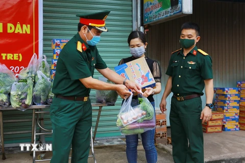 Lực lượng bộ đội thuộc Sư đoàn 302-Quân khu 7 gửi tặng nhu yếu phẩm cho người dân đang thực hiện cách ly tại nhà ở phường Xuân Thanh, Cẩm Mỹ, Đồng Nai. (Ảnh: Lê Xuân/TTXVN)