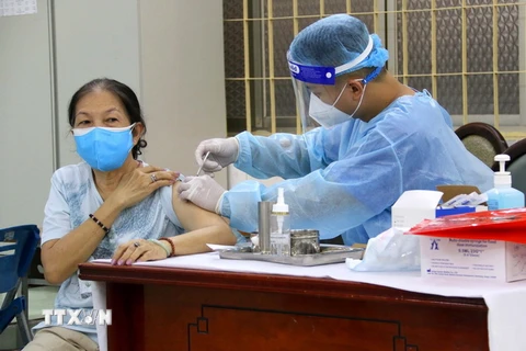 Các y bác sỹ quận 3 tiêm vaccine phòng COVID-19 cho người trên 65 tuổi tại điểm tiêm trường tiểu học Trần Quốc Thảo. (Ảnh: Thanh Vũ/TTXVN)