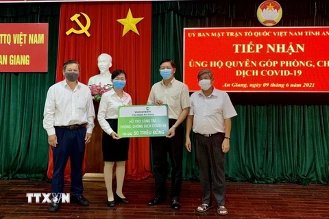 Đại diện Ngân hàng Vietcombank chi nhánh An Giang trao 50 triệu đồng ủng hộ quỹ Phòng, chống dịch COVID-19 tỉnh An Giang. (Ảnh: Thanh Sang/TTXVN)