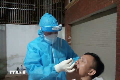 Ngành y tế Hà Tĩnh khẩn trương lấy mẫu xét nghiệm người dân tại khu vực phong tỏa trong đêm. (Ảnh: Hoàng Ngà/TTXVN)