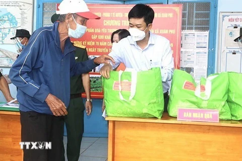 Bí thư Huyện ủy Xuân Lộc Viên Hồng Tiến (áo trắng ) trao quà hỗ trợ cho người dân khó khăn trong đại dịch. (Ảnh: TTXVN phát)