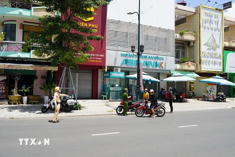 Lực lượng Công an thành phố Tây Ninh tuần tra, lập chốt di động kiểm soát người đi đường không có lý do chính đáng. (Ảnh: Thanh Tân/TTXVN)